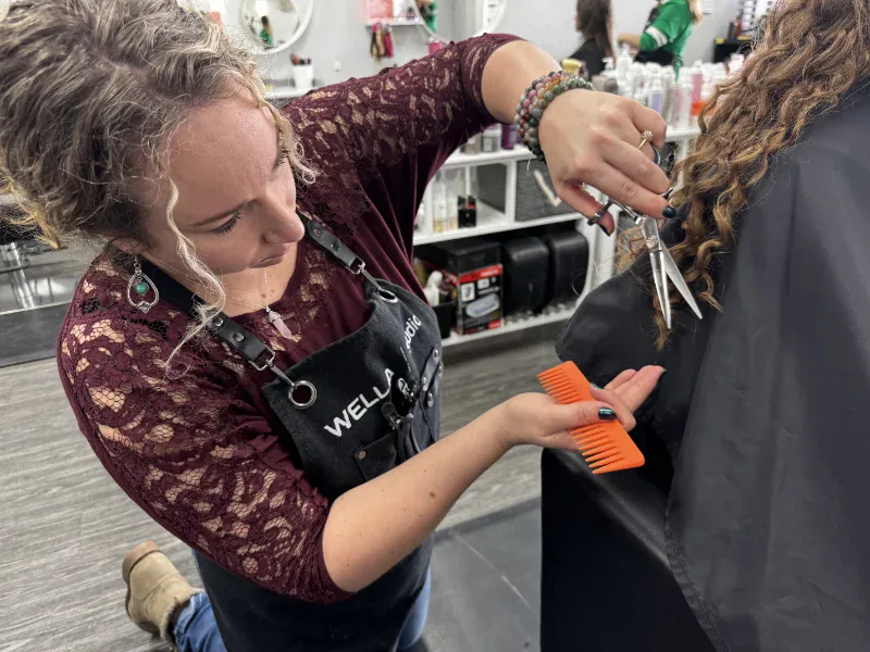 Alexis performing a dry curly haircut using freehand Curl Craft Cut technique in Red Deer